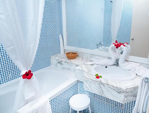 a bathroom with a white sink and a bath tub at Vincci Dar Midoun in Djerba