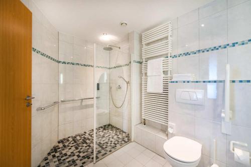 a white bathroom with a shower and a toilet at Diehls Hotel in Koblenz