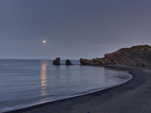 a beach with some rocks in the water at Hôtel La Grande Conque in Cap d'Agde