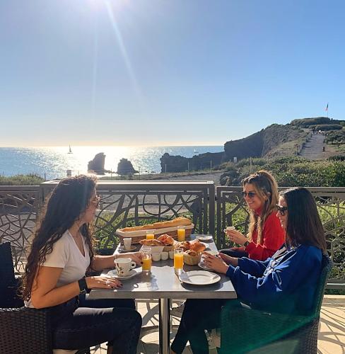 three women sitting at a table eating food at Hôtel La Grande Conque in Cap d'Agde