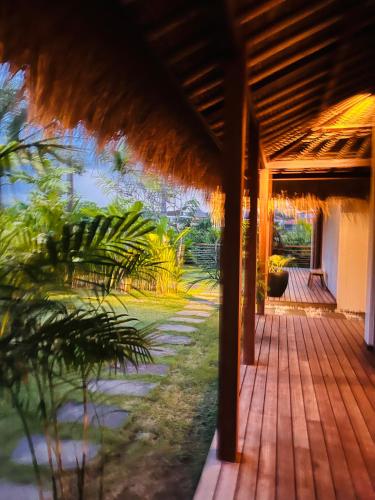 a wooden porch with a view of a garden at La Reserva Villas Bali in Jimbaran
