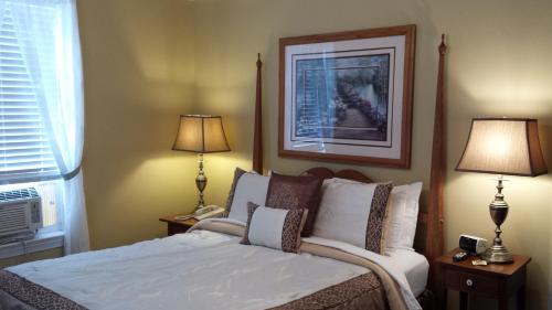 a bedroom with a bed with two lamps and a picture at The Country Inn of Berkeley Springs in Berkeley Springs
