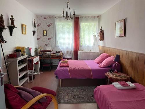 a bedroom with two beds and a table and chairs at Maison Saint Louis in Paray-le-Monial