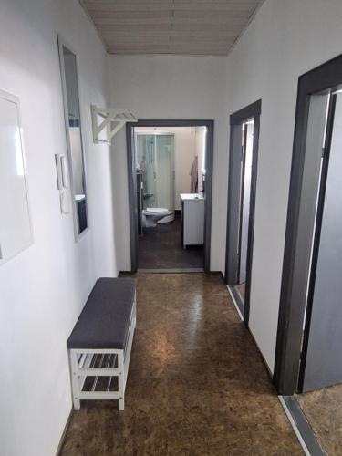 a hallway of a bathroom with a toilet and a bench at Ferienwohnung Wunderlich rot in Münchberg
