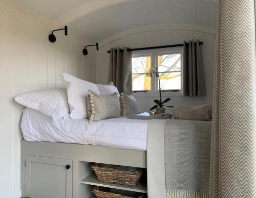 a bed in a room with a window at Self-catering shepherds hut with private garden in Durhams idyllic countryside in Durham