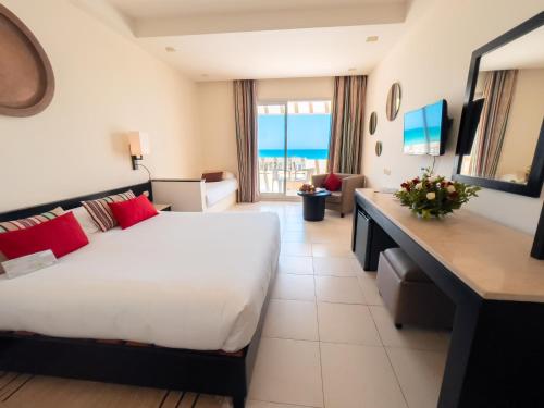 a hotel room with a bed and a view of the ocean at Vincci Dar Midoun in Djerba