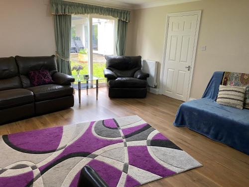 a living room with a couch and a rug at Chase Bungalow in Billericay