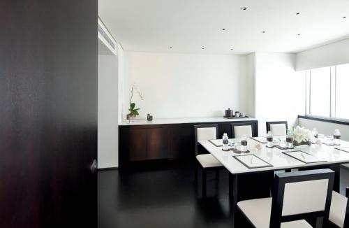 a dining room with a white table and chairs at COMO Metropolitan Bangkok in Bangkok