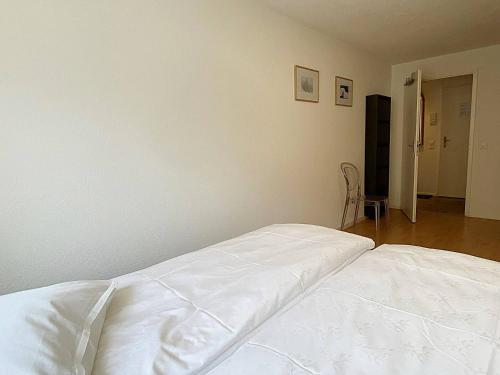 a white bed sitting in a room with at Ski & Kite, zentral, modern, 80m2, Balkon - MU11 in Silvaplana