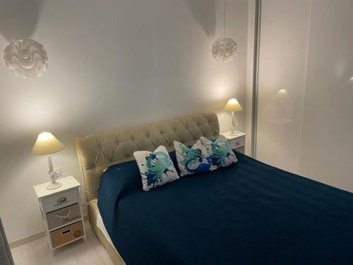 a bedroom with a blue bed with two pillows at Apartman Priko 63A in Mali Lošinj