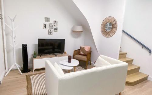 un salon avec un canapé blanc et une télévision dans l'établissement 