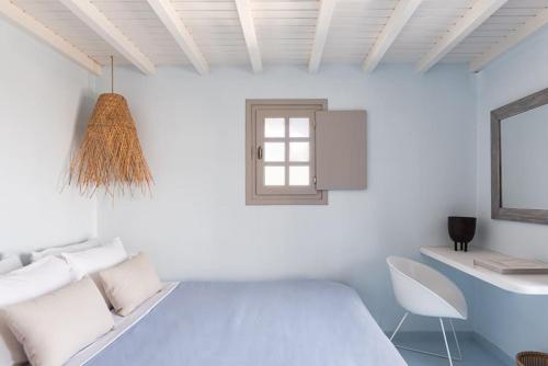 Un dormitorio blanco con una cama y un escritorio. en Aura Homes, Bungalow on Sea - Saint Anna Beach, en Mykonos ciudad