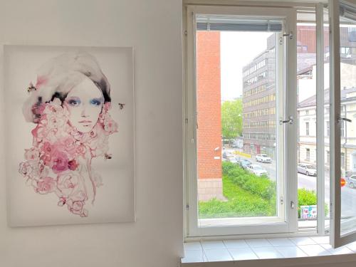 a painting of a woman on a wall next to a window at Central Boutique in Helsinki
