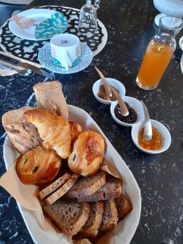 einen Teller Brot und Gebäck auf dem Tisch in der Unterkunft La Sellerie in Romagné