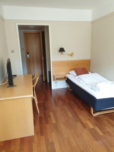 a bedroom with a bed and a desk with a computer at Bremanger Fjord Hotell in Svelgen