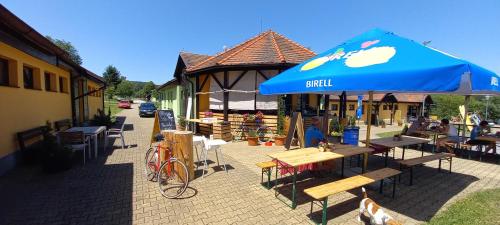 a building with a blue umbrella and tables and chairs at Pláž Výtoň in Přední Výtoň