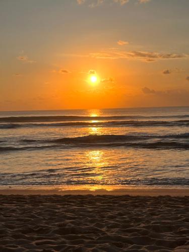 a sunset on the beach with the ocean at La Reserva Villas Bali in Jimbaran