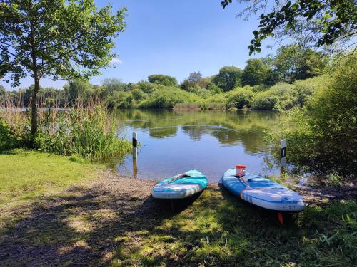 two kayaks sitting on the shore of a river at Naturnahe FeWo zwischen Meer&Seen bei Kiel in Schwentinental