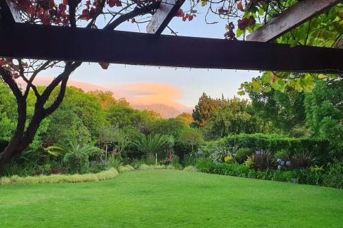 Blick auf einen Garten mit grünem Gras und Bäumen in der Unterkunft Charming Guest Suite in the Constantia Wine Valley in Kapstadt