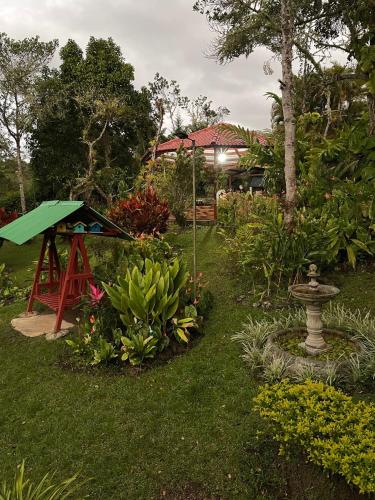 a garden with a bird feeder and some plants at Casa Campestre estilo Chalet Los Pirineos - Cerca a Cali in Cali