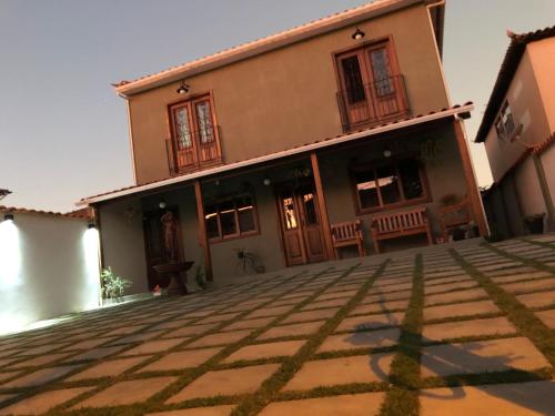 a house with a stone courtyard in front of it at Pouso Primavera in Tiradentes