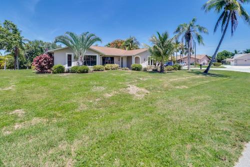 a house with palm trees in a yard at Waterfront Pool Villa with Sailboat access in Cape Coral