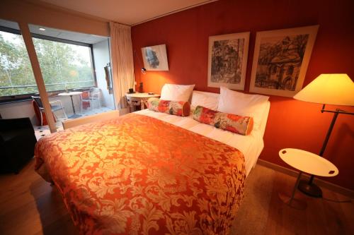 um quarto com uma cama grande e paredes cor-de-laranja em B&B de singel em Utrecht