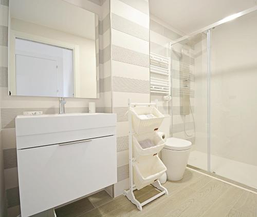 bagno bianco con lavandino e servizi igienici di Impresionante apartamento con piscina en Sanxenxo a Sanxenxo