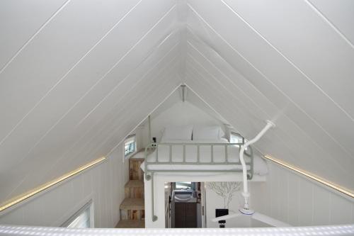 a white room with a staircase in a attic at The Shepherd's Hut, Quex Park Estate in Birchington