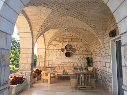 patio ze stołem i kanapą w ceglanej ścianie w obiekcie Casa Zucchetta w mieście Locorotondo