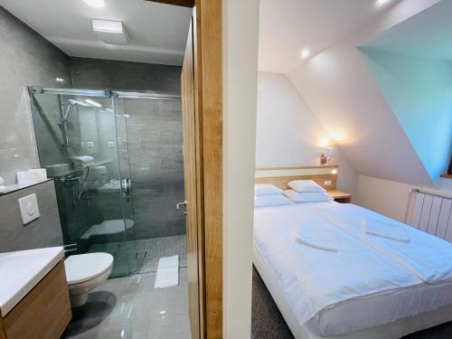 uma casa de banho com uma cama e uma cabina de duche em vidro em Mikes Deluxe Home em Balatonfüred