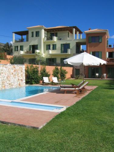 a large house with a swimming pool and an umbrella at Villa Brio in Skala Kefalonias