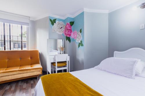 a white bedroom with a bed and a chair at ApartaSuites & Hotel Bogota Suamox in Bogotá
