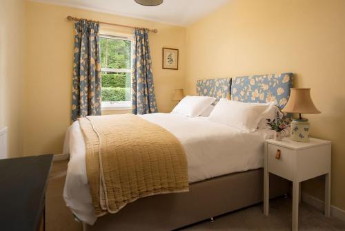 a bedroom with a large bed and a window at Pirnie Cottage in Kelso