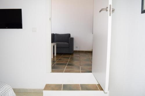 a living room with a chair and a mirror at Hotel Mirablau in Aguadulce
