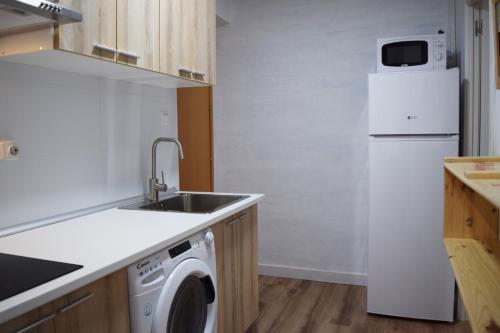 a kitchen with a sink and a white refrigerator at Hotel Mirablau in Aguadulce