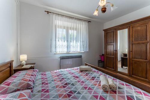 ein Schlafzimmer mit einem großen Bett und einem Fenster in der Unterkunft Apartman Ana in Pula