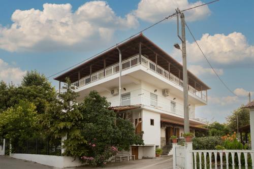 a white building with a balcony on top of it at Gravanis Studios in Platamonas
