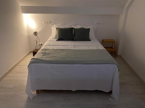 a bedroom with a large white bed with green pillows at Villa Sesimbra in Sesimbra