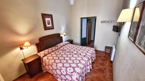 um quarto com uma cama com um cobertor vermelho em Casa Tinoco Casa Rural Categoria Superior em Fuenteheridos