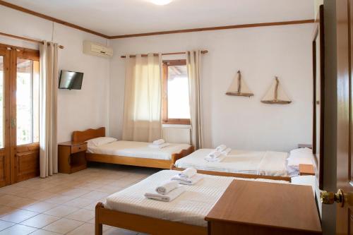 a hotel room with two beds and a table at Gravanis Studios in Platamonas