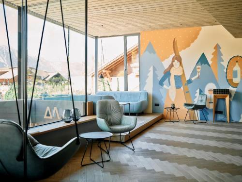 a room with chairs and a wall with a mural at ARX Guesthouse in Schladming