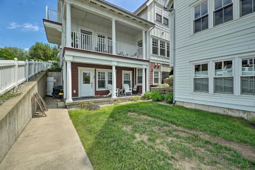 a white house with a porch and a yard at Grand Haven Condo Walk to Lake and Pool Access! in Grand Haven