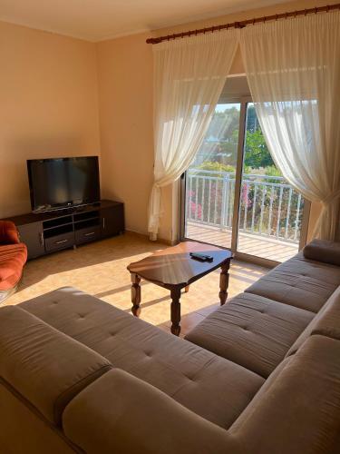 a living room with a couch and a tv and a table at Apartment Kune,Shëngjin in Shëngjin