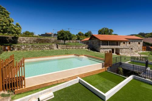 a swimming pool in a yard with a house at Hotel La Rectoral in Covelo