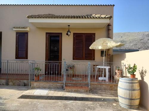 a house with a fence and an umbrella at Monolocale da Andrea in Custonaci