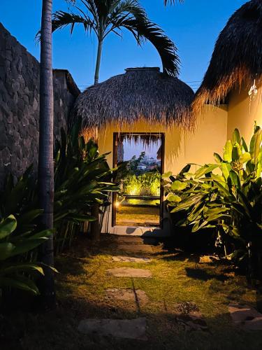 a house with a thatch roof and a window at La Reserva Villas Bali in Jimbaran