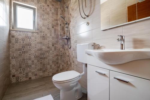 Un baño con un inodoro blanco y un lavabo. en Apartments Glorija, en Neum