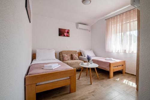 una pequeña habitación con una cama y un sofá en Apartments Glorija, en Neum