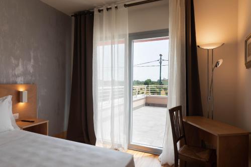 a hotel room with a bed and a sliding glass door at Torre Antica Venice Airport Hotel in Tessera
